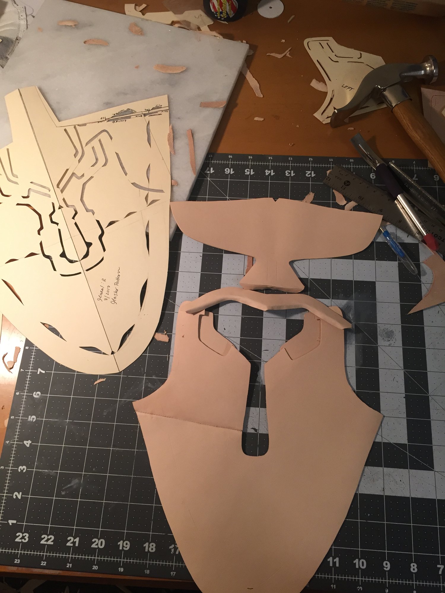 Leather pattern pieces being hand-cut on a cutting mat
